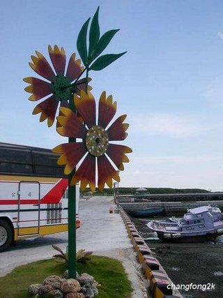 風車在這幾年成為澎湖造景藝術主要的題材，大街小巷都可以看得到風車的裝置藝術，這是在跨海大橋旁的風車圖騰，澎湖嘛！風的故鄉