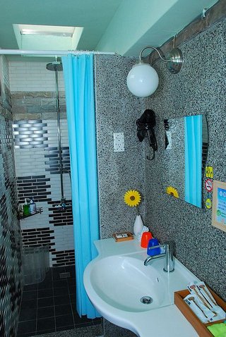 浴室牆壁以洗石子及小花磚拼貼