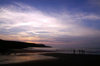 這邊的夕陽雖然不像西嶼燈塔的夕陽是落入海裡，然而有沙灘映照餘暉，折射出的夕陽雲光飽富耀眼的鋒芒